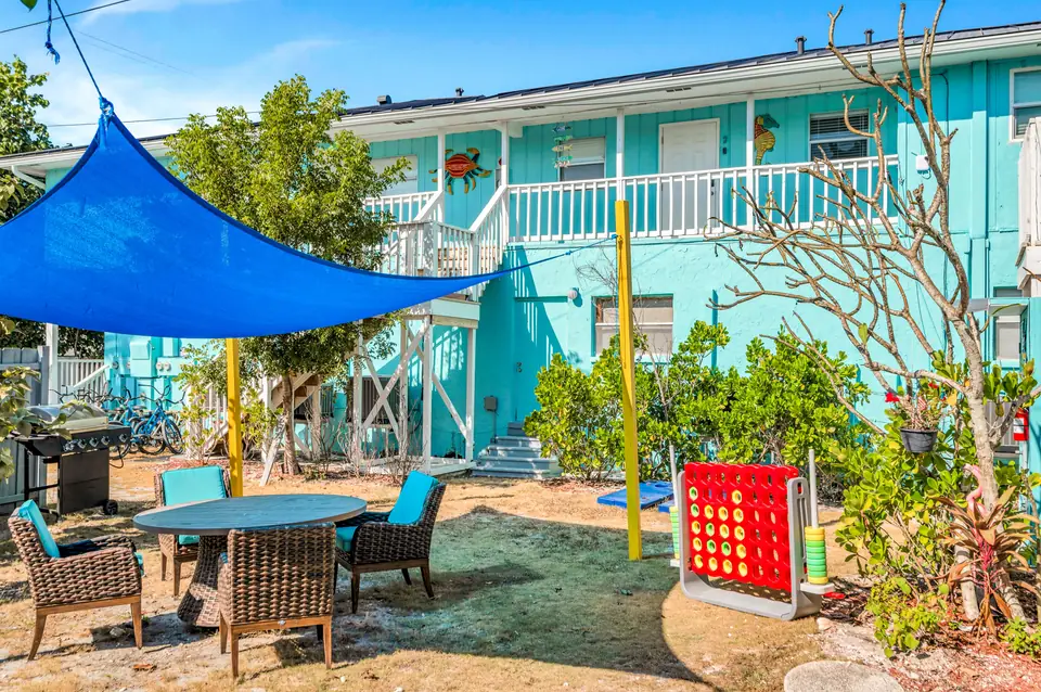 Patio table and chairs under the blue shade sail